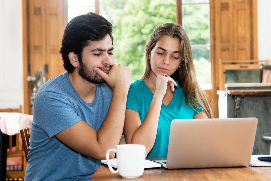 Couple staring at their computer.