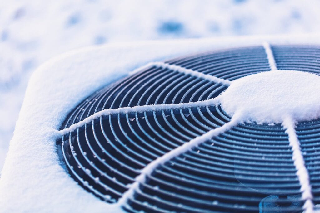 Air conditioning unit outside covered in snow in Austin