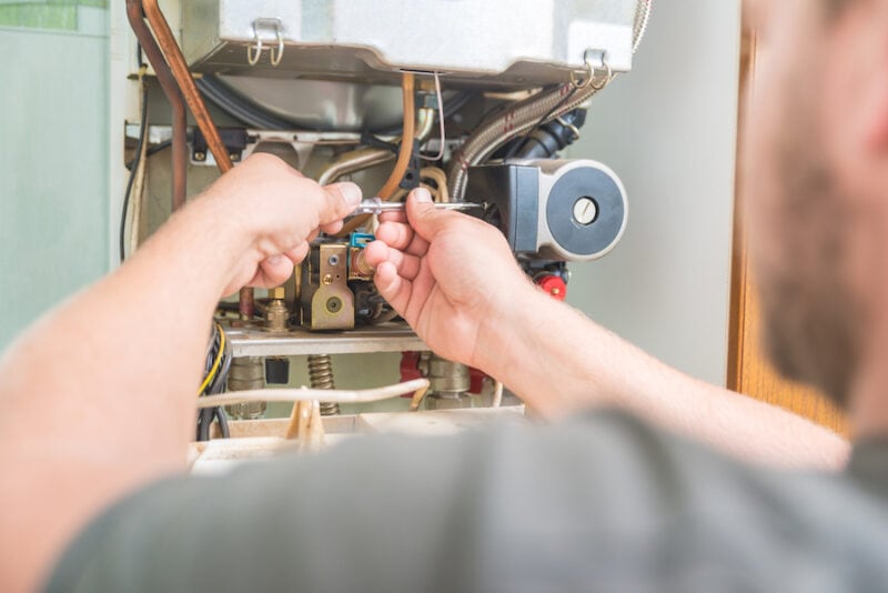 Blue Air Technician repairing Gas Furnace