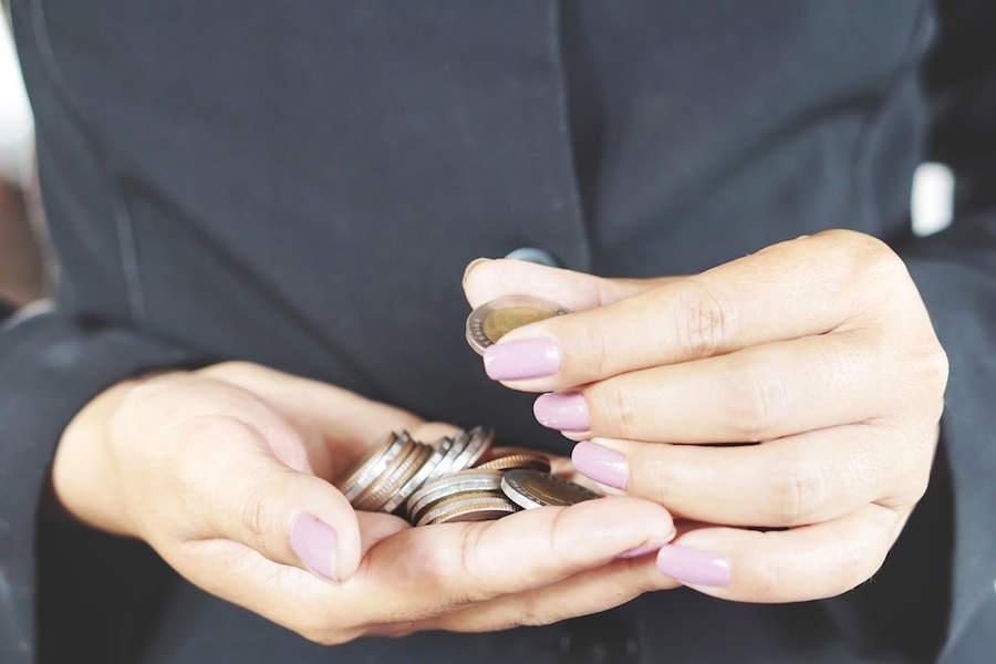 Close up of female hands holding coins saving money in Cedar Park